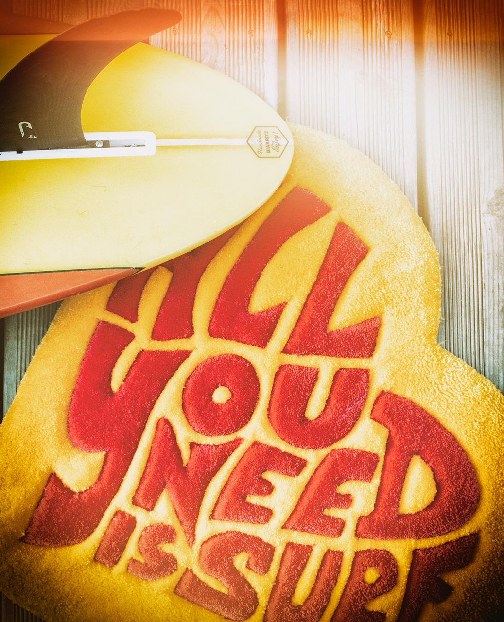 Serviette ALL YOU NEED IS SURF avec une aileron jaune, sur du bois